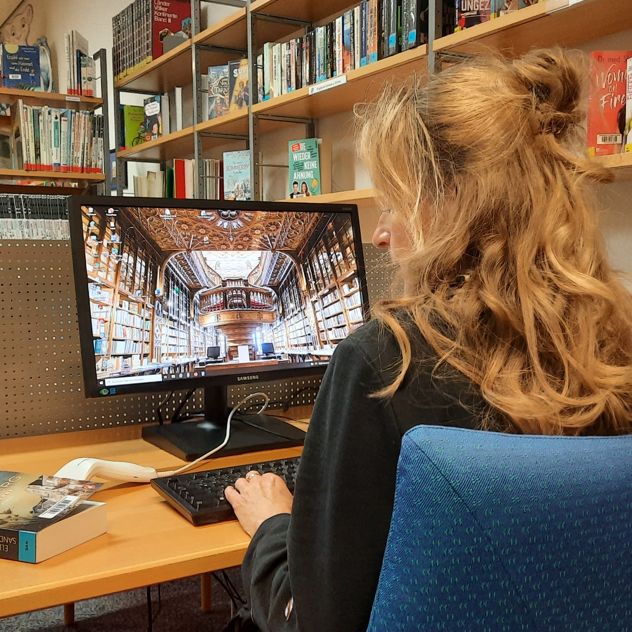 Mitarbeiterin der Stadtbibliothek vor Computer